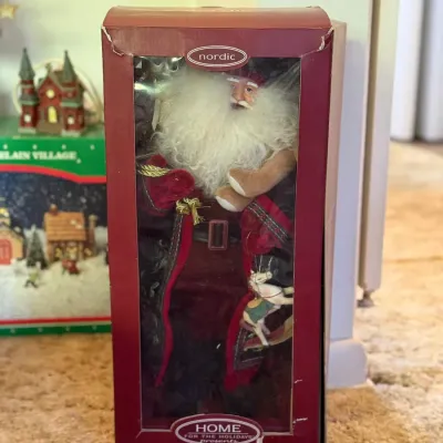 Sale Photo Thumbnail #64: Nordic 'Visions of Santa' Home for the Holidays collectible Santa Claus figure in original packaging. Features a detailed fabric outfit, faux fur trim, and miniature holiday accessories.