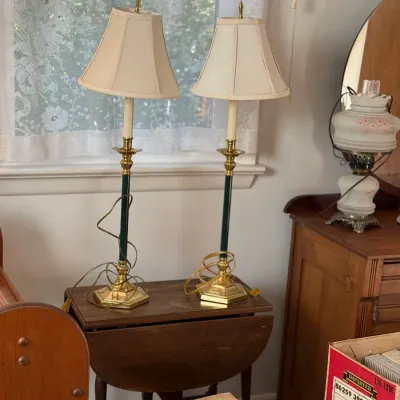 Sale Photo Thumbnail #16: Pair of brass and dark green slender table lamps with fabric bell shades, sitting on a wooden drop-leaf side table.