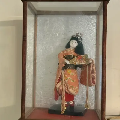 Sale Photo Thumbnail #152: Vintage Japanese geisha doll in a silk patterned kimono, housed inside a glass and wooden display case.