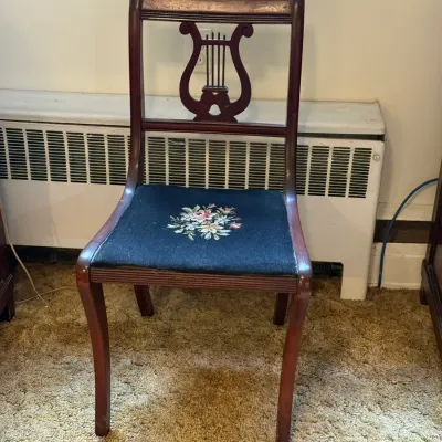 Sale Photo Thumbnail #47: Vintage Duncan Phyfe style lyre-back side chair featuring a dark mahogany finish and a black needlepoint upholstered seat with a floral motif.