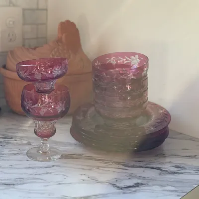 Sale Photo Thumbnail #3: Set of vintage cranberry flashed cut glass dessert glassware featuring delicate etched floral and grape motifs, including footed sherbet cups and matching saucers.