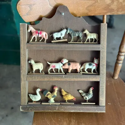 Sale Photo Thumbnail #274: Vintage wall-mounted shadow box filled with miniature farm animal figurines, including horses, cows, sheep, dogs, pigs, and poultry.