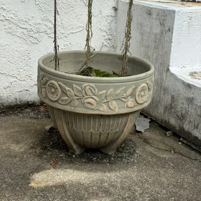 Sale Photo Thumbnail #199: Weathered concrete or stone outdoor planter featuring embossed floral garland detail along the rim.