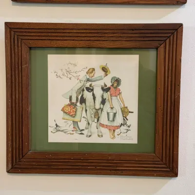 Sale Photo Thumbnail #53: Framed Norman Rockwell illustration print depicting a pastoral scene, housed in a rustic fluted wooden frame with green matting.
