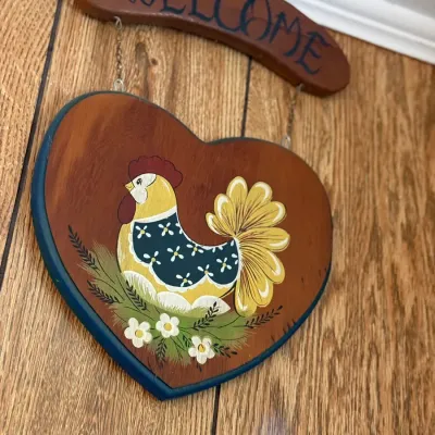 Sale Photo Thumbnail #182: Vintage hand-painted wooden hanging welcome sign with a rooster motif and heart-shaped plaque attached by small chains.