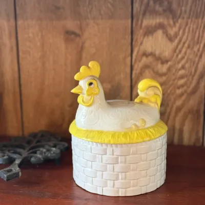 Sale Photo Thumbnail #180: Vintage ceramic hen-on-nest covered dish featuring a white basketweave base and yellow-accented chicken lid.