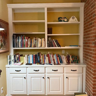 Sale Photo Thumbnail #36: Large white built-in bookcase unit featuring four drawers, four cabinet doors, upper open shelving, and various books and decorative items.