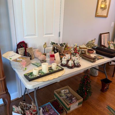 Sale Photo Thumbnail #30: Folding table display featuring a variety of home decor items, candle sets, small figurines, condiments, and holiday ornament boxes stored underneath.