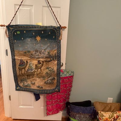 Sale Photo Thumbnail #66: Woven nativity-themed wall tapestry with hanging rod, accompanied by an assortment of decorative throw pillows on the floor.