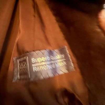 Sale Photo Thumbnail #61: Interior lining and 'Saga Mink Superb Quality' brand label of a vintage brown mink fur coat.