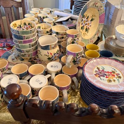 Sale Photo Thumbnail #15: Large set of ceramic dinnerware featuring hand-painted floral motifs, including stacks of plates, bowls, a pitcher, and numerous matching mugs.