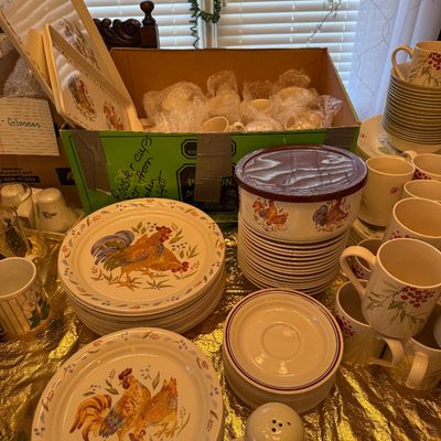 Sale Photo Thumbnail #12: Large set of rooster-themed ceramic tableware, featuring plates, bowls, serving trays, and matching mugs arranged on a table.