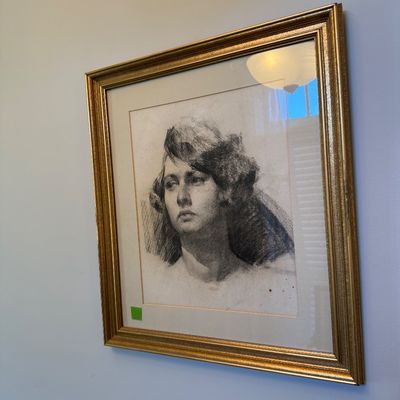 Sale Photo Thumbnail #40: Framed charcoal portrait drawing of a woman, presented in a mat and an ornate gold-finished wood frame.