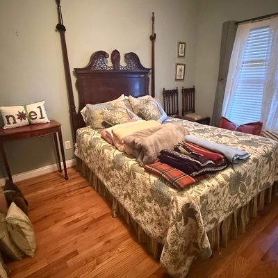 Sale Photo Thumbnail #58: Traditional four-poster bed set with carved mahogany headboard, patterned quilt, and extra blankets.