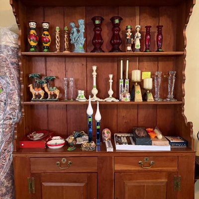 Sale Photo Thumbnail #34: Vintage pine hutch and buffet featuring scalloped trim, filled with an assortment of decorative candlesticks, figurines, and holiday tabletop items.