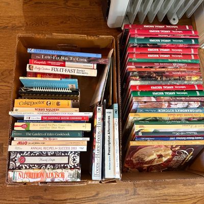 Sale Photo Thumbnail #80: Two cardboard boxes filled with assorted cookbooks, including Southern Living Annual Recipes and Betty Crocker titles.