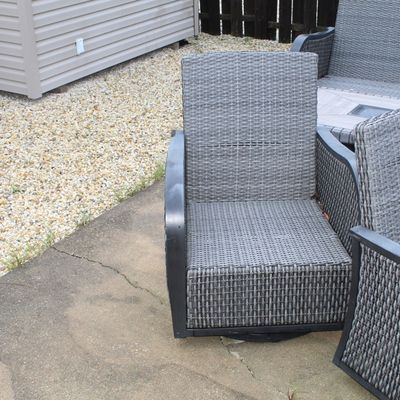 Sale Photo Thumbnail #52: Modern outdoor woven resin armchair in a grey finish with dark frame accents, set on a swivel base.