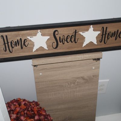 Sale Photo Thumbnail #39: Farmhouse-style wooden wall sign reading 'Home Sweet Home' with white distressed star accents in a black frame.