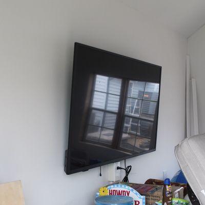 Sale Photo Thumbnail #61: Wall-mounted flat-screen television with a dark slim frame, shown turned off.