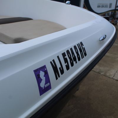 Sale Photo Thumbnail #48: Front bow section of a white motorboat displaying a New Jersey registration decal and lettering.
