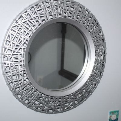 Sale Photo Thumbnail #33: Round wall mirror featuring a silver-painted basketweave frame, mounted on a plain wall.