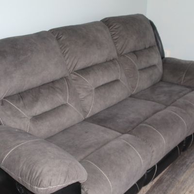 Sale Photo Thumbnail #29: Contemporary grey microfiber reclining sofa with black faux-leather trim and contrast stitching.