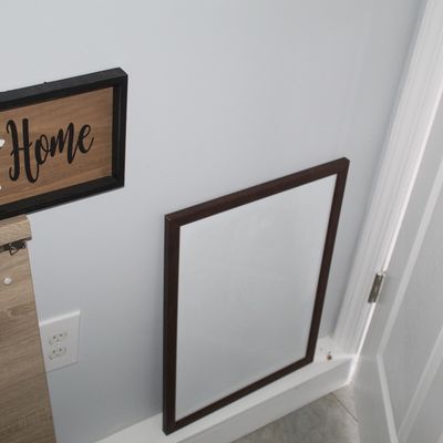 Sale Photo Thumbnail #38: Framed white magnetic or erase board displayed on the floor next to a rustic "Home" wall sign.