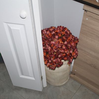 Sale Photo Thumbnail #40: Faux autumnal floral arrangement in a cream-colored ceramic urn, placed in a corner nook.