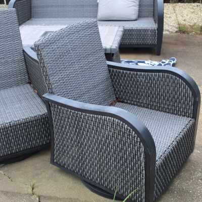 Sale Photo Thumbnail #53: Modern grey resin wicker patio seating set, including swivel armchairs and a matching sofa on a concrete patio.