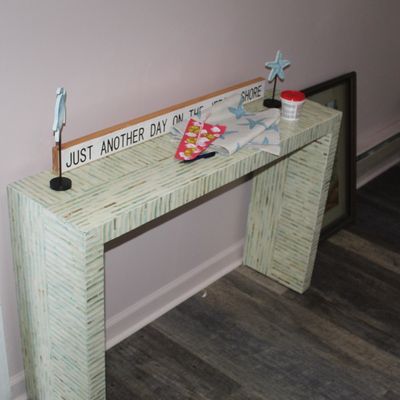 Sale Photo Thumbnail #10: Contemporary console table with a light green mosaic tile pattern, topped with coastal-themed decor including starfish figurines and a wooden sign.