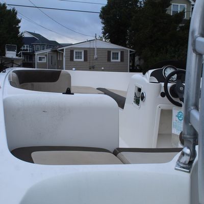 Sale Photo Thumbnail #45: Interior view of a Bayliner motorboat featuring two-tone vinyl seating and a central steering console with gauge.