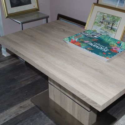 Sale Photo Thumbnail #11: Modern light wood grain dining table with a thick rectangular top and pedestal base, featuring a colorful tropical serving tray.