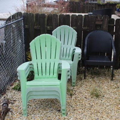 Sale Photo Thumbnail #60: Set of stacked mint green plastic Adirondack-style patio chairs alongside a black resin wicker outdoor chair.