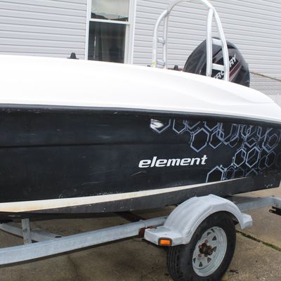 Sale Photo Thumbnail #43: Bayliner Element deck boat featuring a black and white hull with geometric graphics, a Mercury outboard motor, and a ski tow arch, mounted on a single-axle trailer.