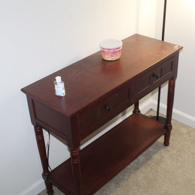 Sale Photo Thumbnail #76: Dark cherry wood sofa table featuring two drawers, dark knobs, turned legs, and a bottom display shelf.