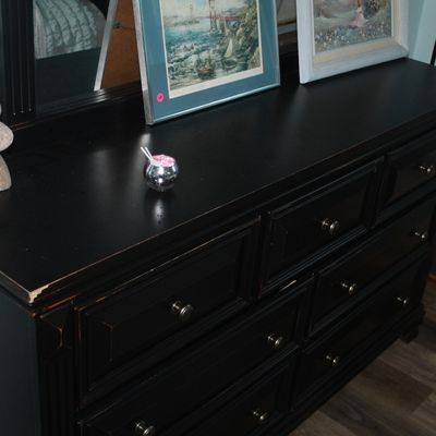 Sale Photo Thumbnail #87: Black painted wooden double dresser with a matching mirror and metallic knobs, displaying slight edge wear.