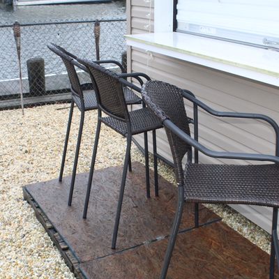 Sale Photo Thumbnail #56: Set of three contemporary dark brown resin wicker outdoor bar stools with metal frames and armrests.