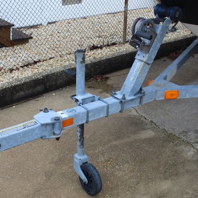 Sale Photo Thumbnail #44: Galvanized steel boat trailer tongue assembly featuring a manual winch mechanism, swing-away coupler, and a swivel jack wheel.