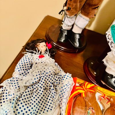 Sale Photo Thumbnail #62: Collection of souvenir dolls and wooden castanets, including a doll dressed in a polka-dot flamenco dress and another in traditional male attire.