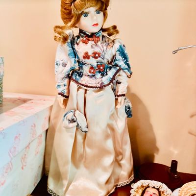 Sale Photo Thumbnail #60: Vintage porcelain collector doll featuring reddish-brown hair and an ornate floral and satin period-style dress.