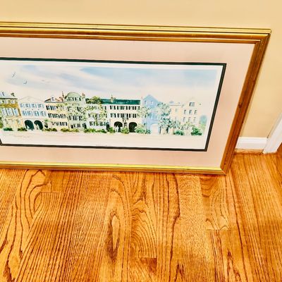 Sale Photo Thumbnail #64: Large framed watercolor print depicting Rainbow Row in Charleston, South Carolina, housed in a metallic gold-finished frame with a double mat.