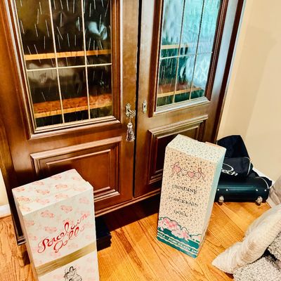 Sale Photo Thumbnail #63: Traditional wooden display cabinet with textured glass doors, set beside two vintage patterned porcelain doll boxes.