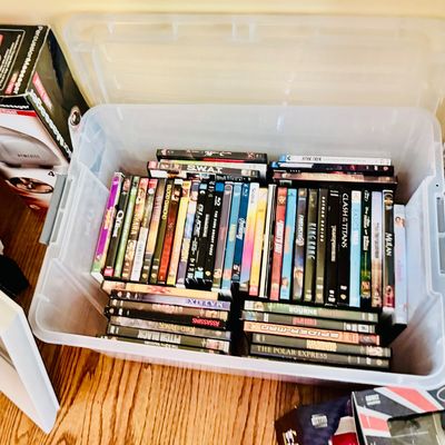 Sale Photo Thumbnail #81: Large clear plastic storage bin filled with various DVD and Blu-ray movie titles.