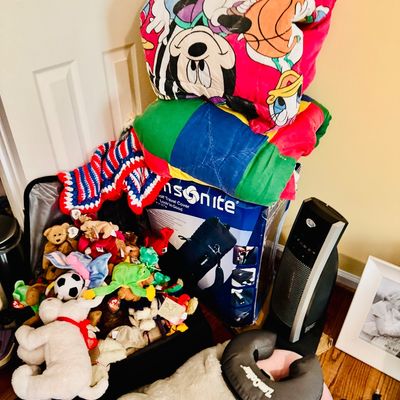 Sale Photo Thumbnail #30: Collection of household items including plush toys, a vintage Disney Mickey Mouse comforter, a Samsonite box, space heater, and neck pillows.