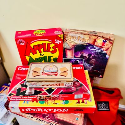 Sale Photo Thumbnail #80: Collection of vintage and modern board games including Apples to Apples, Harry Potter jigsaw puzzle, Operation, Scrabble, and a Fig Newtons tins.