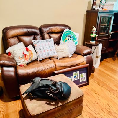Sale Photo Thumbnail #55: Brown leather reclining loveseat paired with a matching suede ottoman and assorted throw pillows.