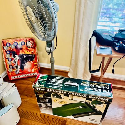 Sale Photo Thumbnail #73: Lasko pedestal fan along with boxed items including The Ultimate Putting System and Mongoose rollerblades.