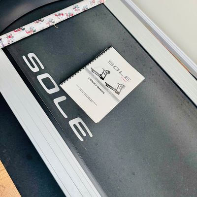 Sale Photo Thumbnail #47: Sole Fitness treadmill featuring an owner's manual placed on the walking belt, appearing in well-maintained condition.
