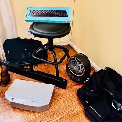Sale Photo Thumbnail #76: Collection of household items and electronics, including a black rolling stool, Logitech keyboard in box, Dreo desk fan, soundbar, and decorative gorilla figurine.
