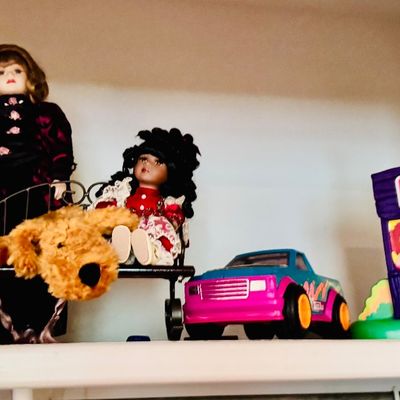 Sale Photo Thumbnail #86: Collection of vintage toys and dolls, including a yellow M&M candy dispenser, porcelain dolls on a mini wrought iron bench, a colorful toy pickup truck, and an Ice Age sno-cone machine.
